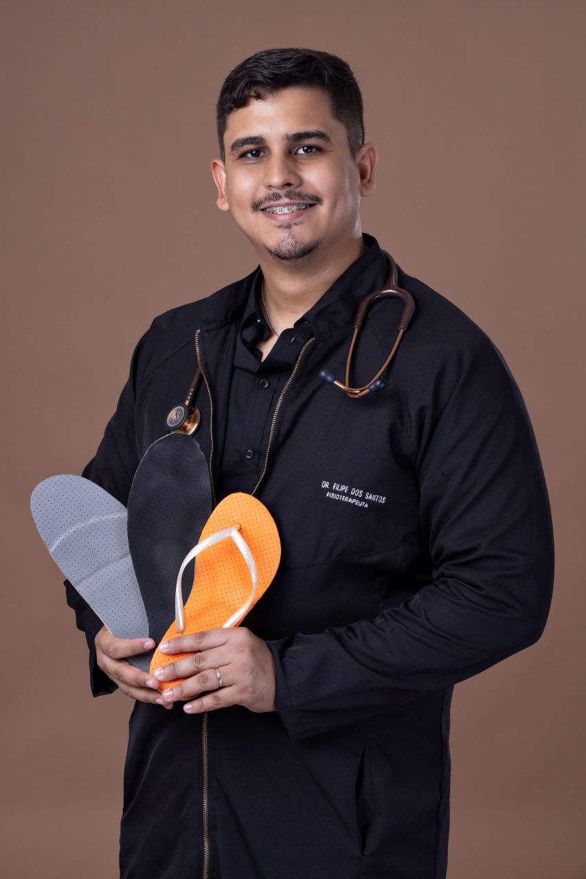 Dr. Filipe segurando palmilhas terapêuticas